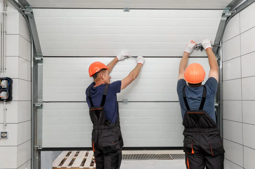 Technician repairing a commercial overhead garage door